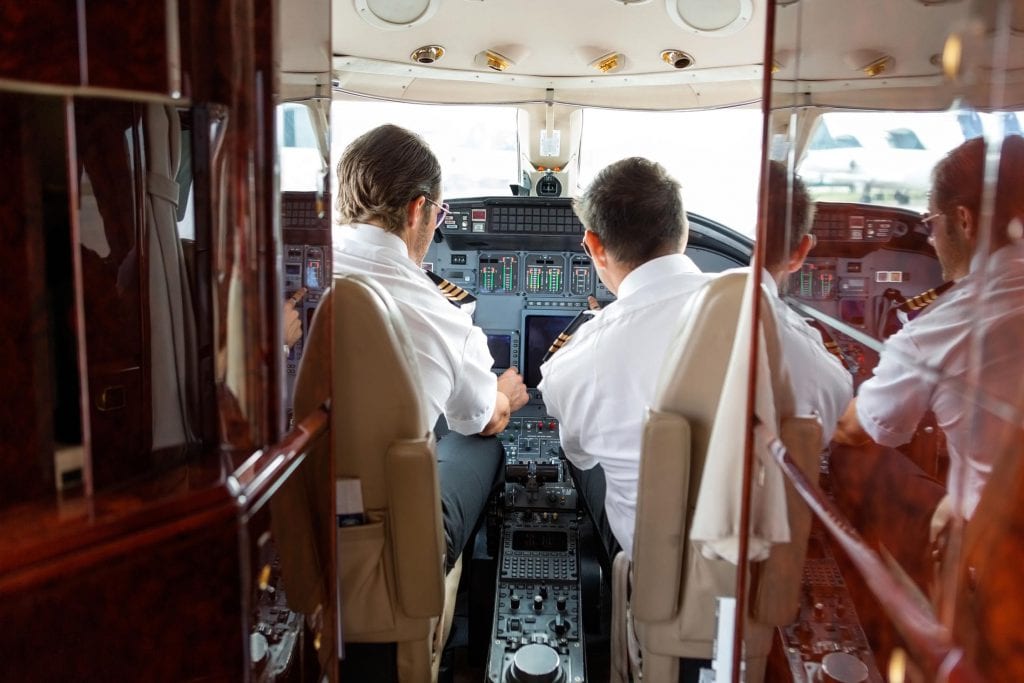 Pilots Operating Controls Of Private Jet