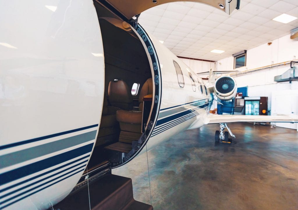 Private jet with open door in a hangar